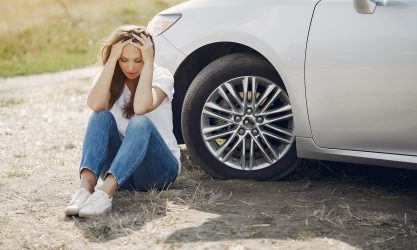 Worried Young Woman Sitting Near Broken Automobile At 4173090